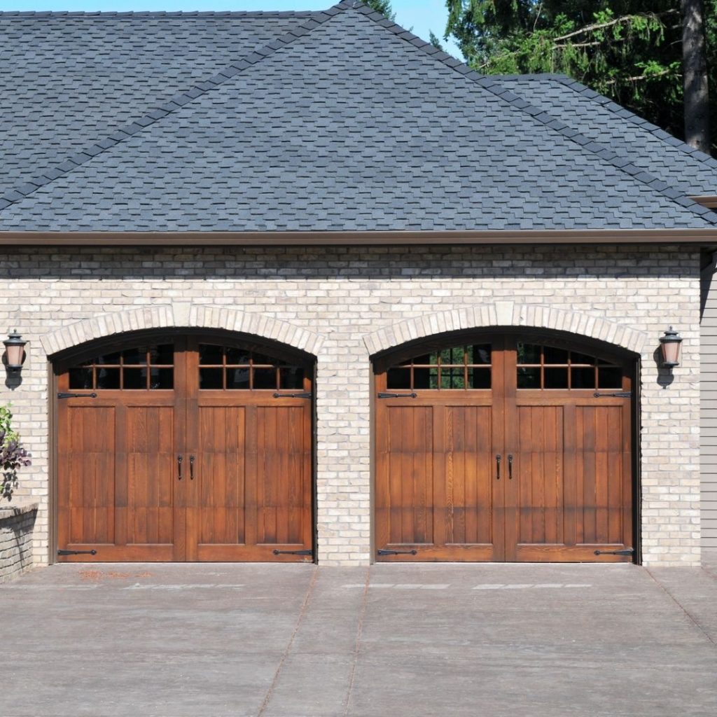 two wooden garage doors on a stone house