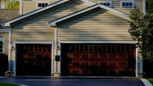 Two wooden garage doors side by side with one bigger than the other